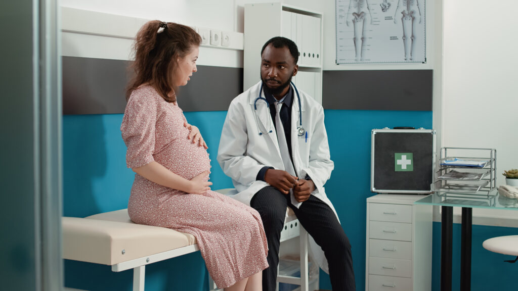 Pregnant woman speaking with a doctor